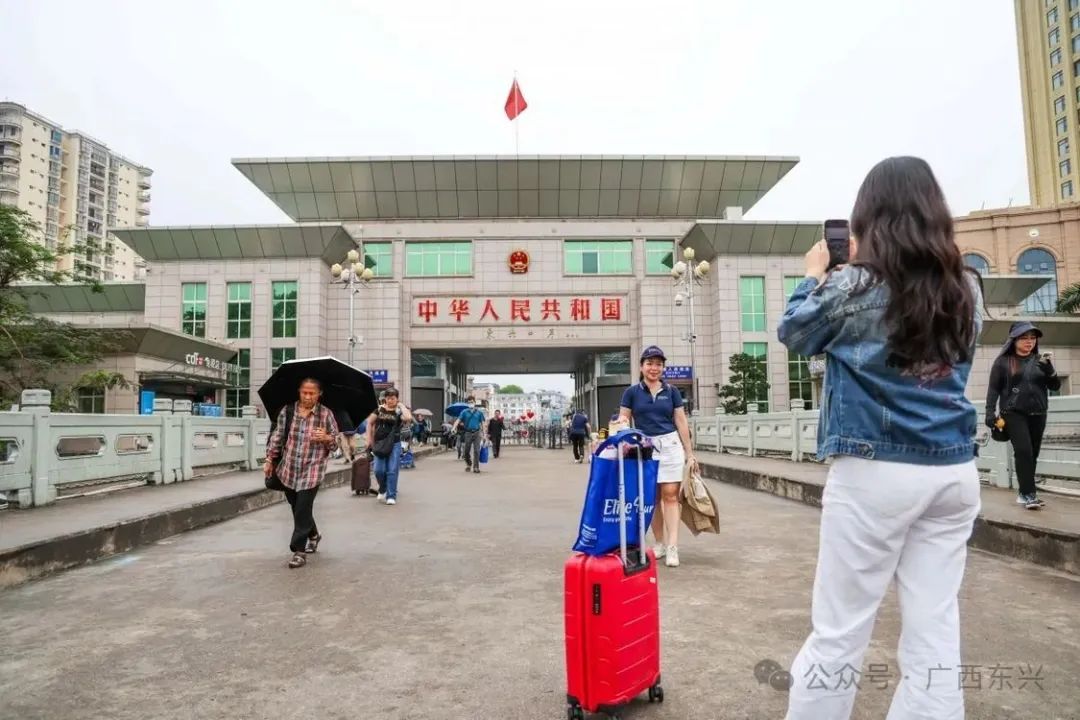 25日上午，游客在中越边境的东兴市跨境大桥一桥上留影。
