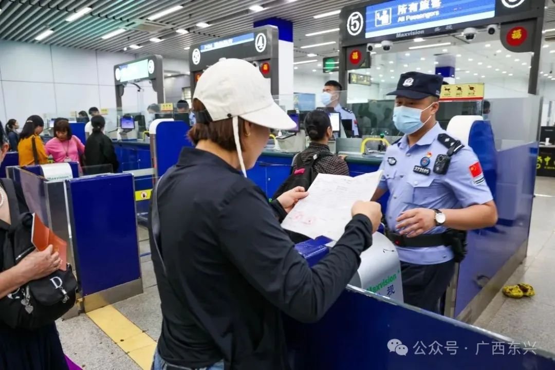 25日上午，在东兴口岸出入境大厅内，游客和边民在排队办理入关手续。
